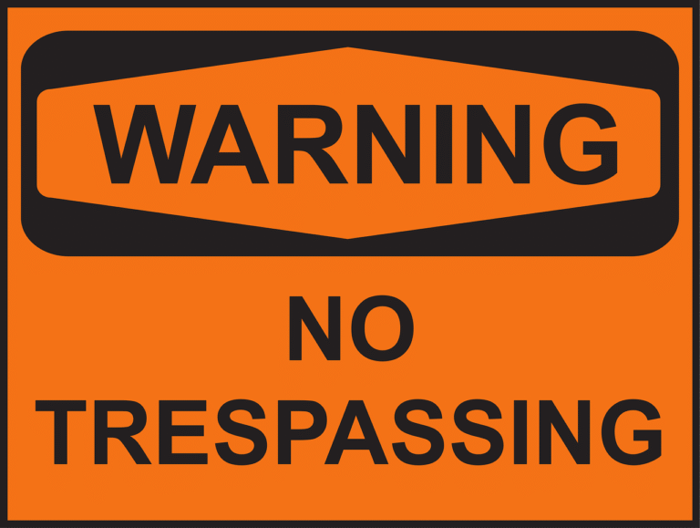 Bright orange no trespassing warning sign